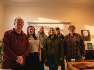 Vänsterpartiet Falkenbergs styrelse står uppradade framför en whiteboard.