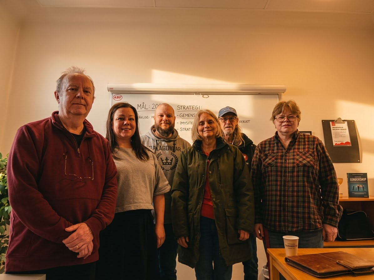 Vänsterpartiet Falkenbergs styrelse står uppradade framför en whiteboard.